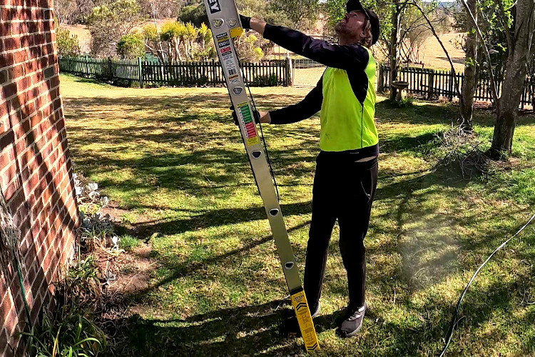 
Proficient gutter cleaning professional sets up their extension ladder in wollongong.